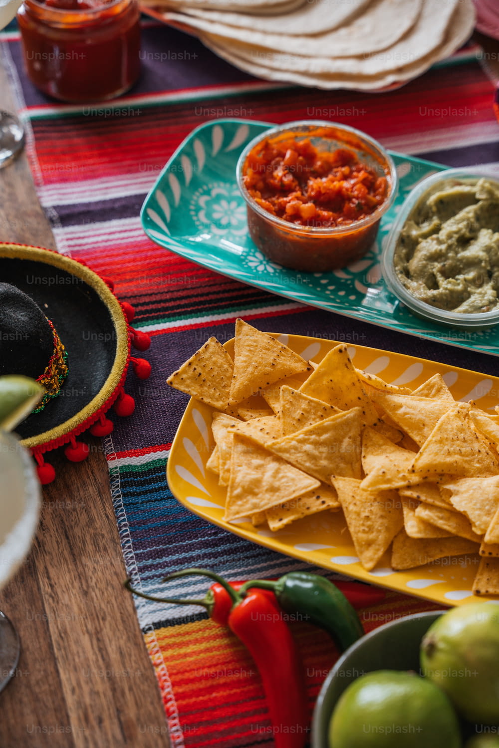a table topped with plates of nachos and guacamole