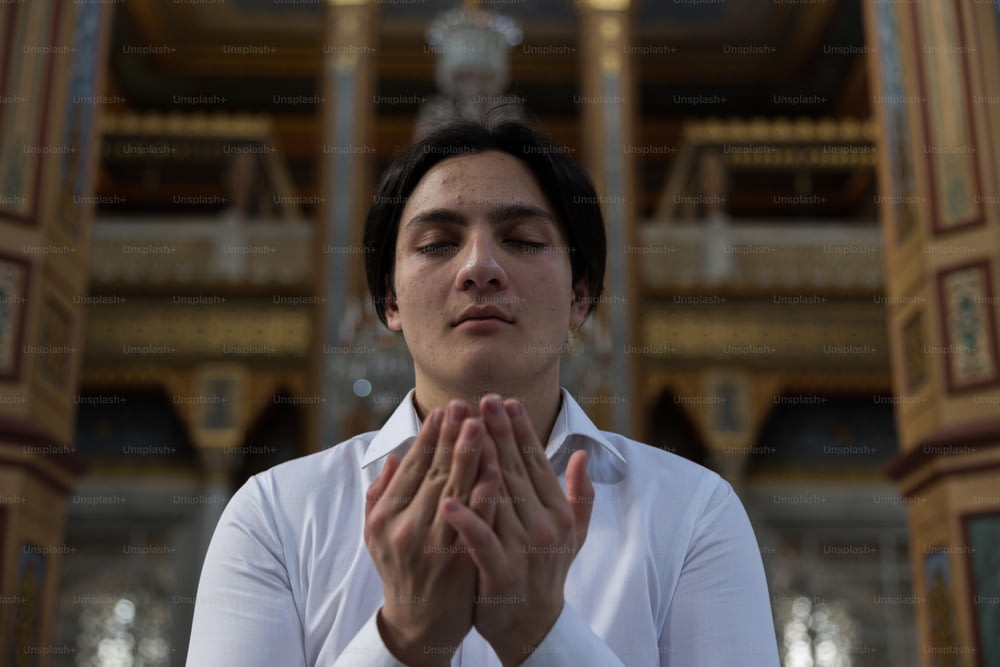 a woman in a white shirt is praying