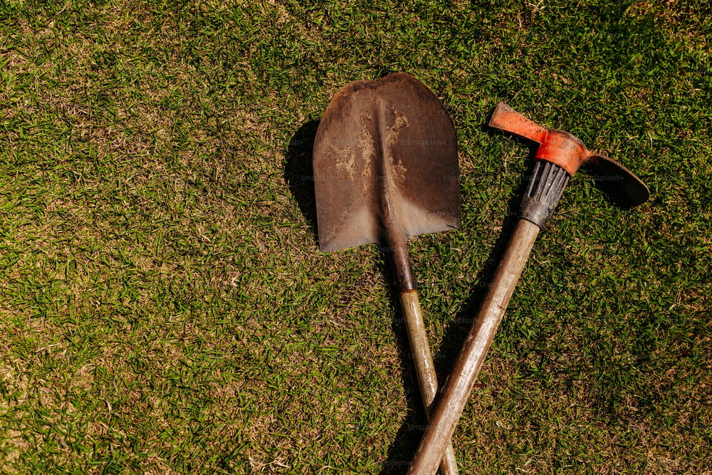 a shovel and a shovel laying on the grass