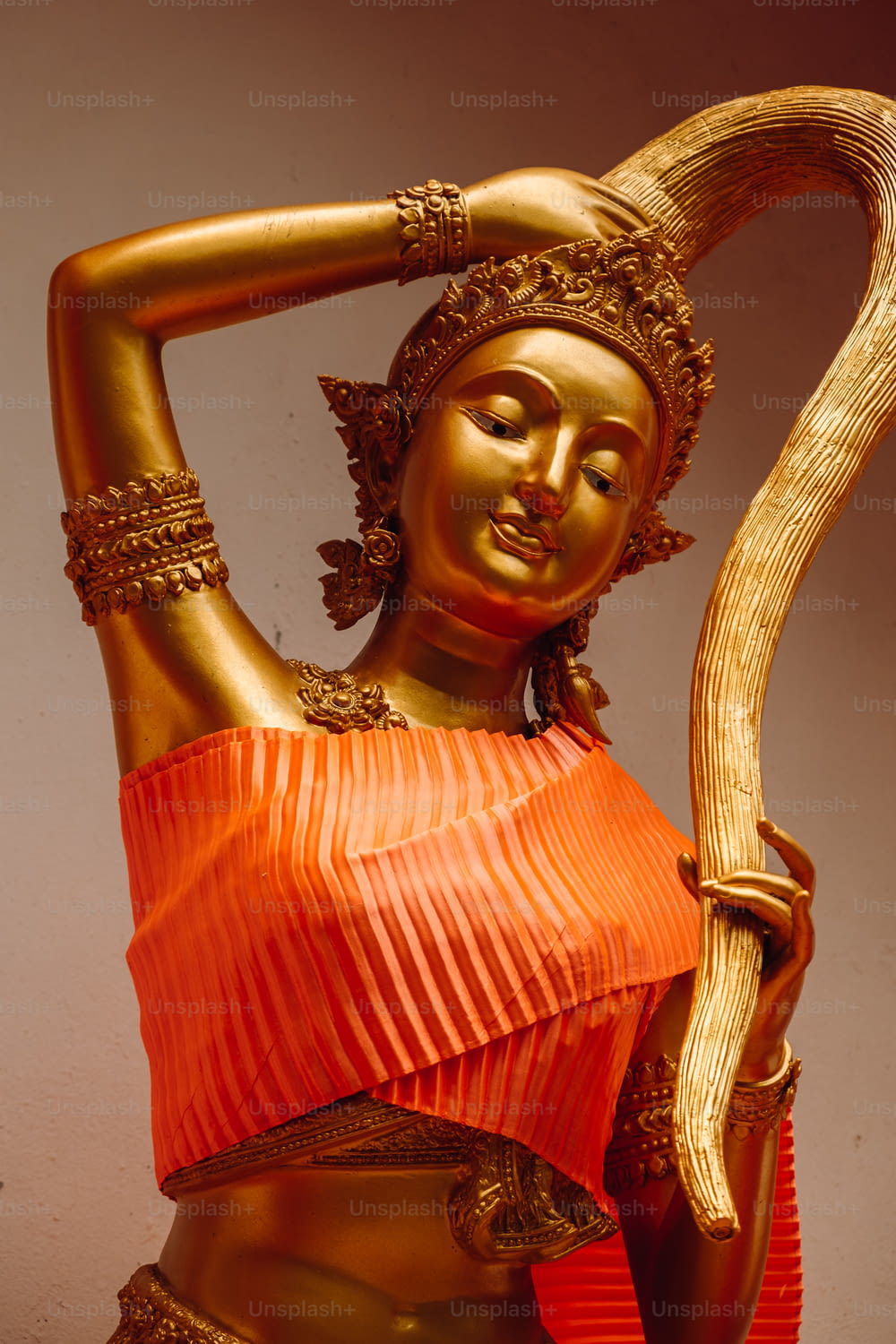 uma estátua de ouro de uma mulher que segura uma cobra