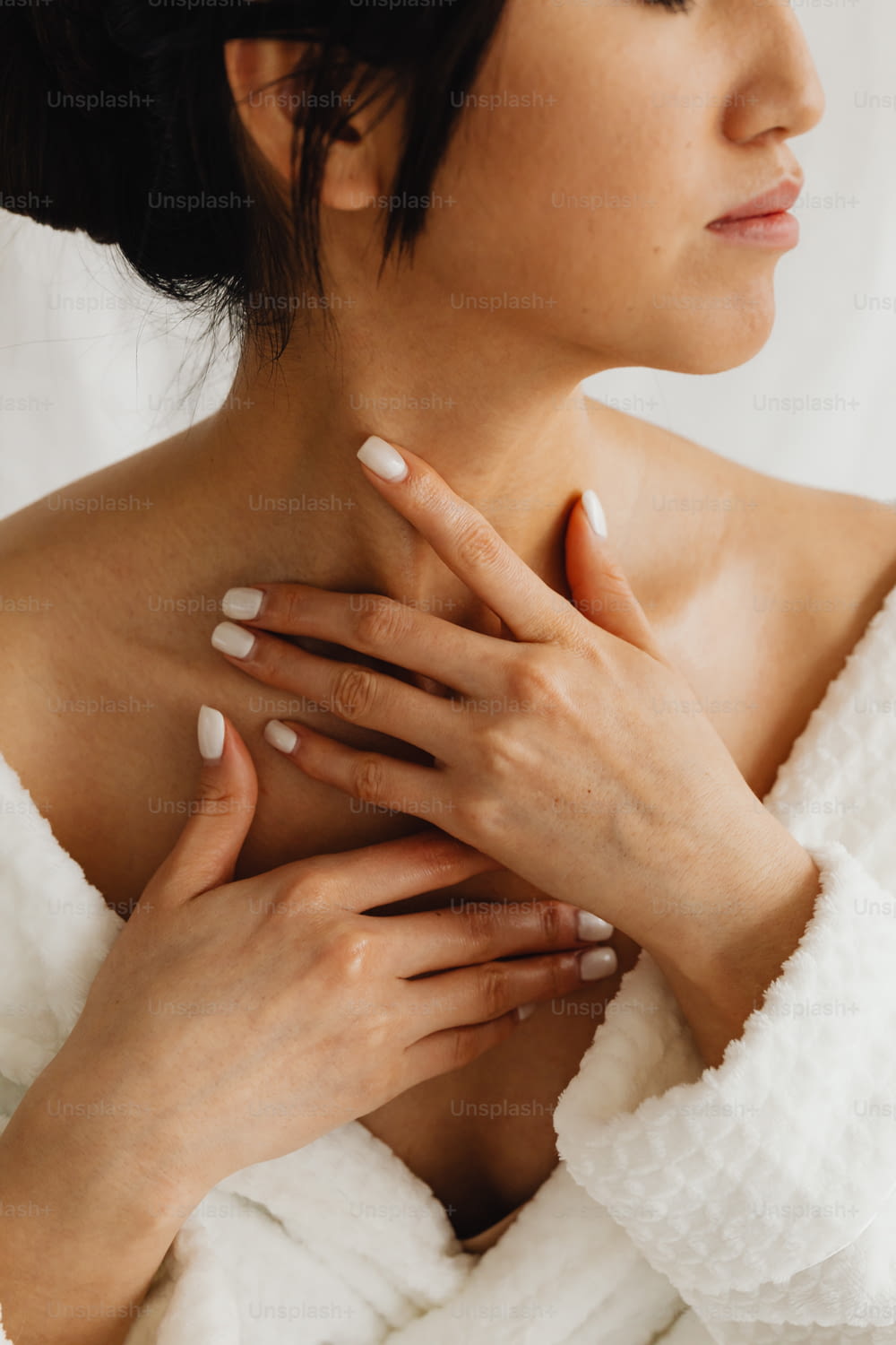 a woman in a bathrobe with her hands on her chest