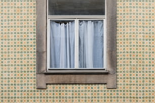 uma janela que tem uma cortina nela
