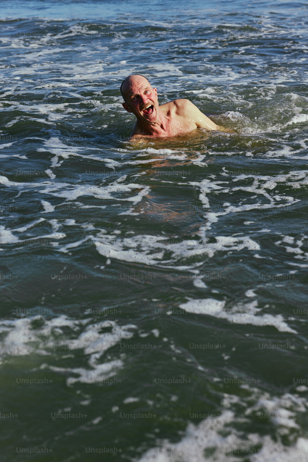 Ein Mann, der mit dem Kopf über dem Wasser im Meer schwimmt