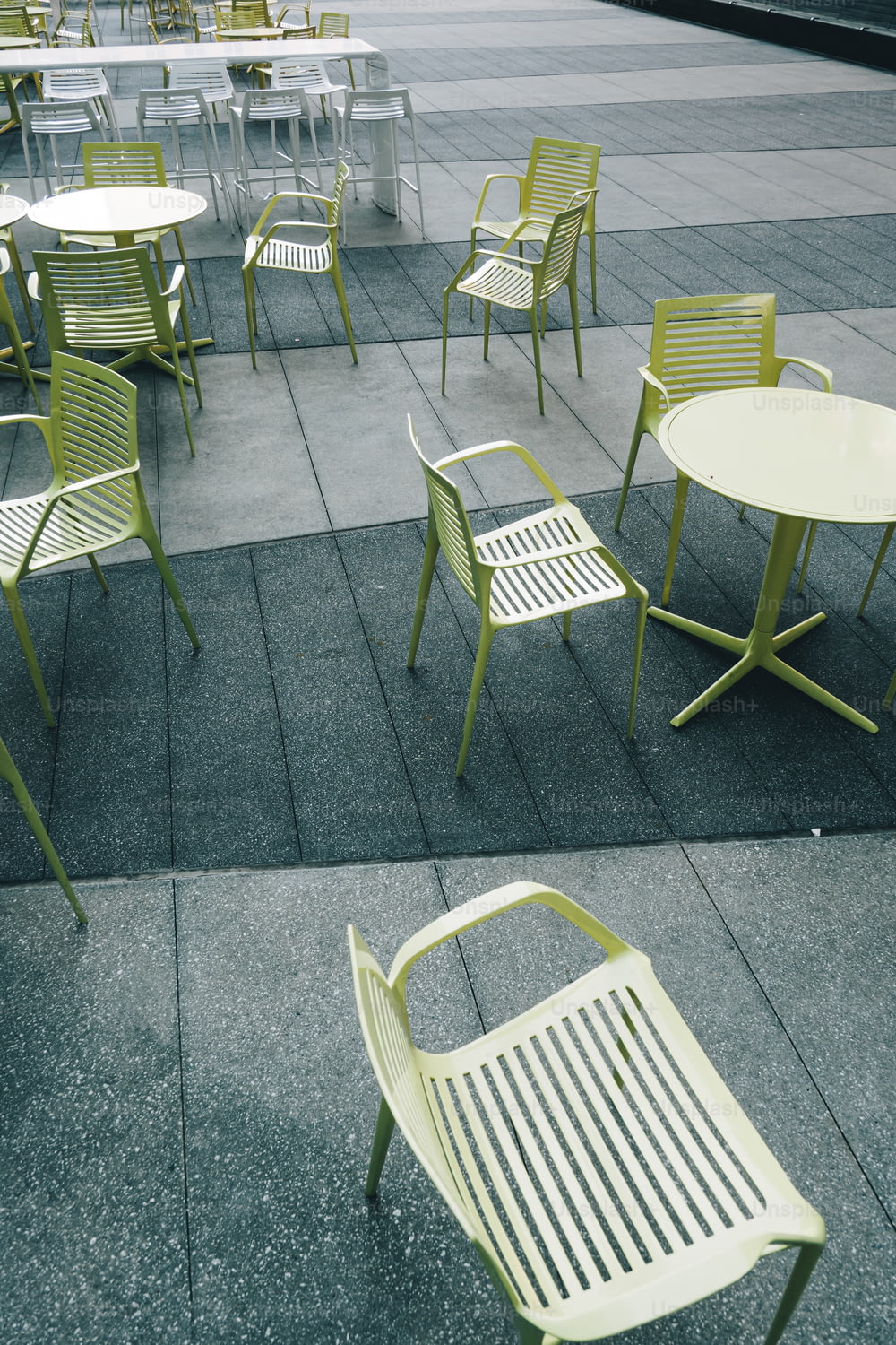eine Reihe von Stühlen und Tischen auf einem Bürgersteig