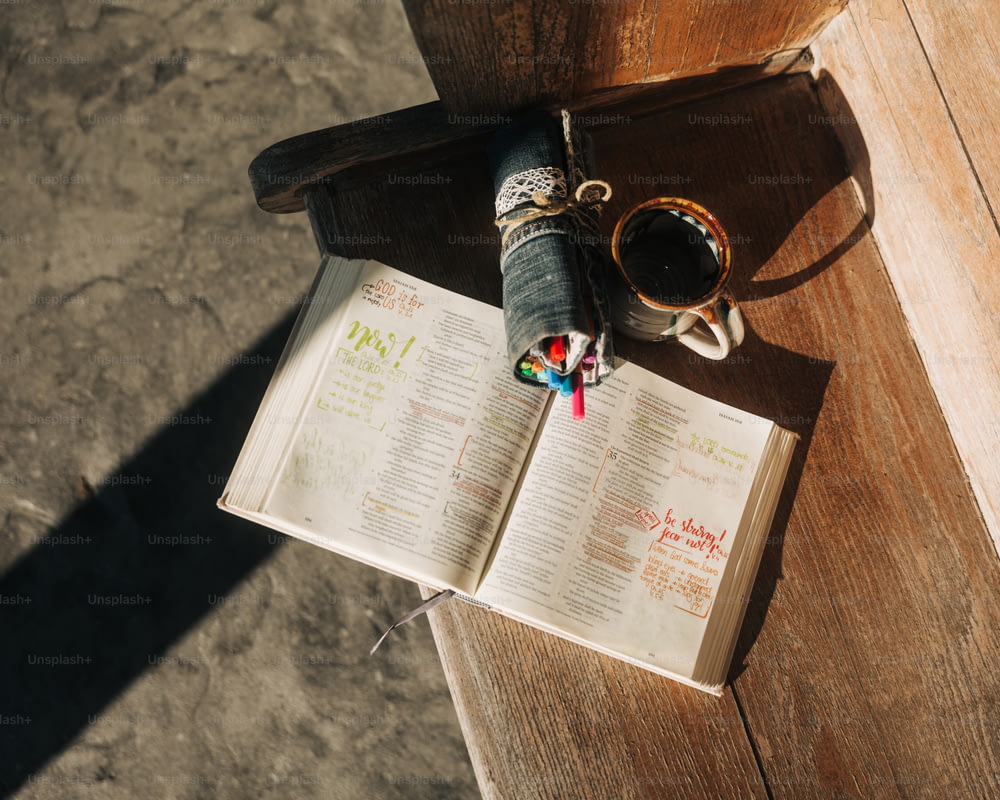 un libro aperto e una tazza di caffè su un tavolo di legno