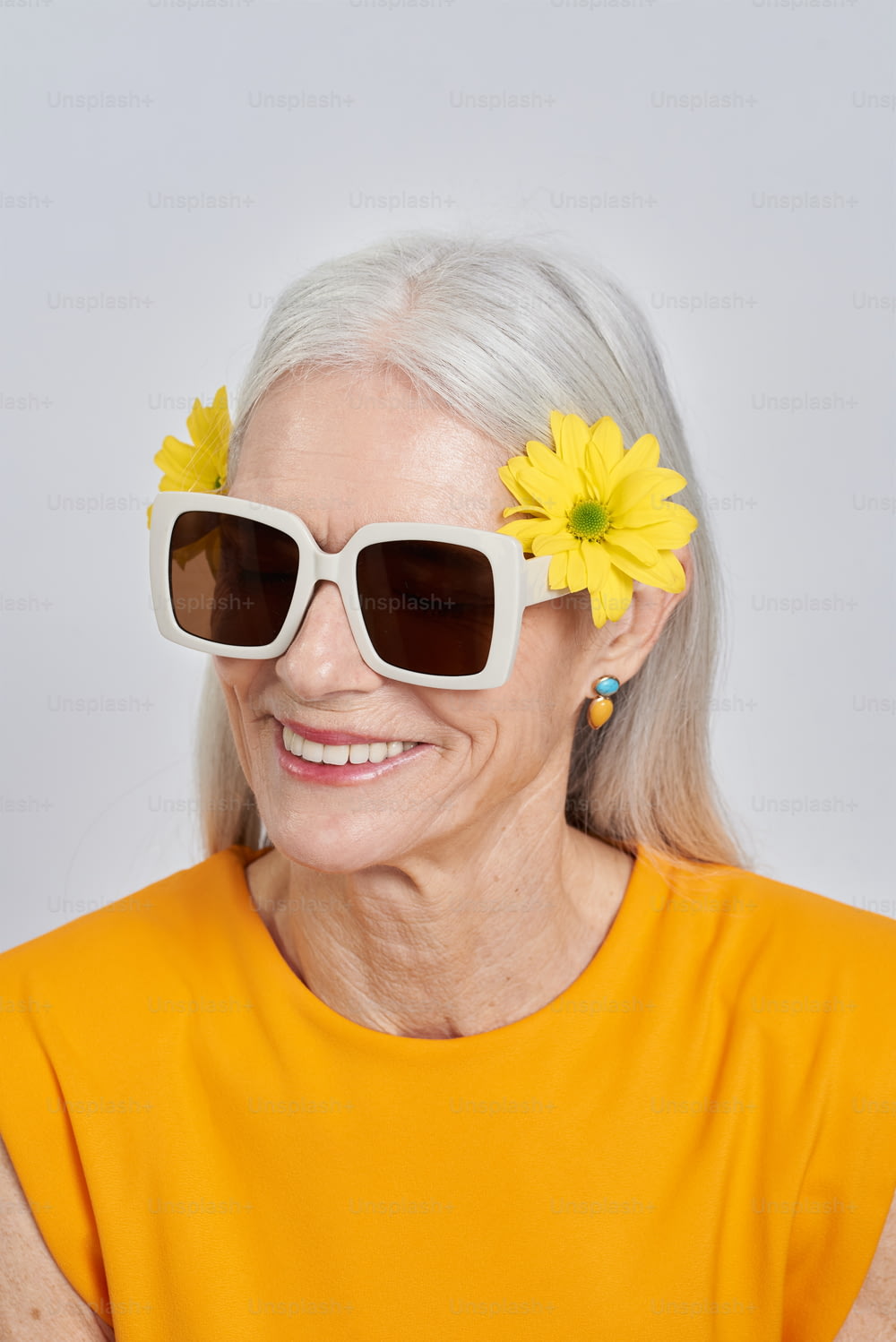 an older woman wearing sun glasses and a flower in her hair