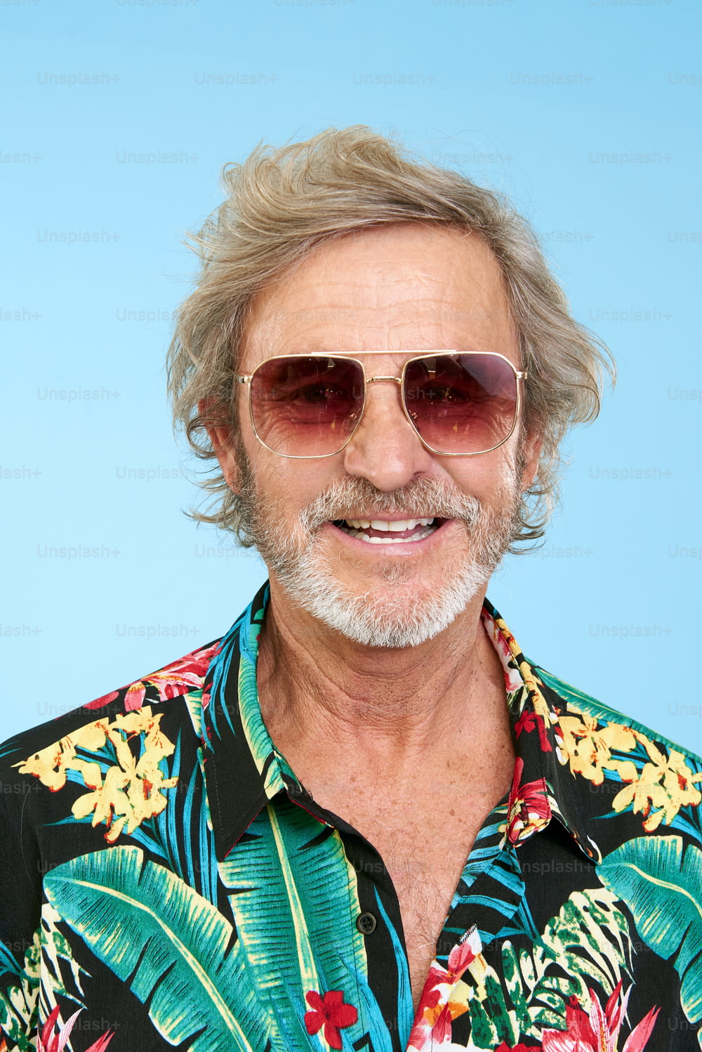 a man wearing a hawaiian shirt and sunglasses