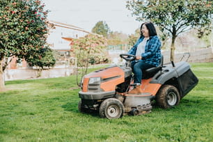 uma mulher que monta na parte de trás de um cortador de grama