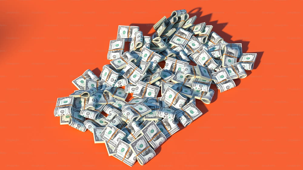 a pile of money sitting on top of an orange surface