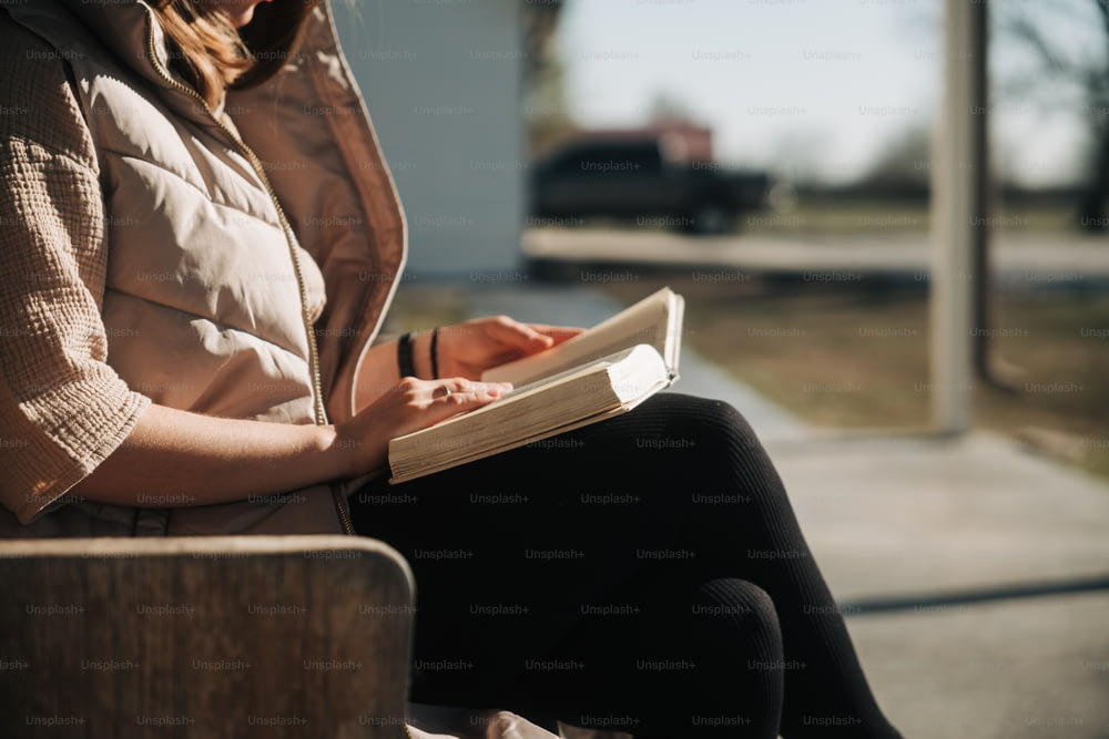 una donna seduta su una panchina che scrive su un libro