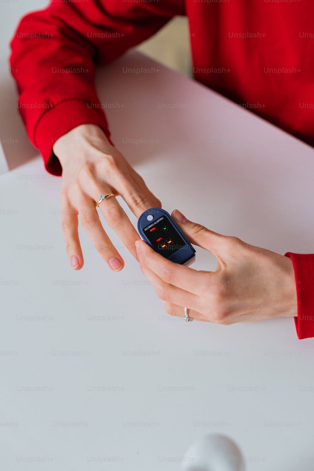 a woman in a red shirt is holding a cell phone