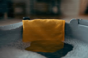 a yellow towel sitting in a bathtub filled with water