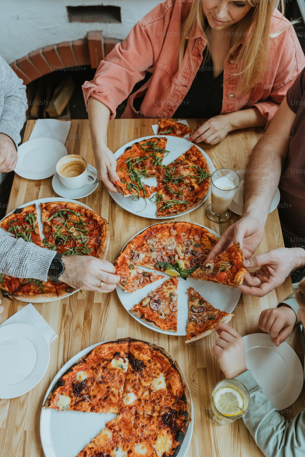 un groupe de personnes assises autour d’une table avec une pizza