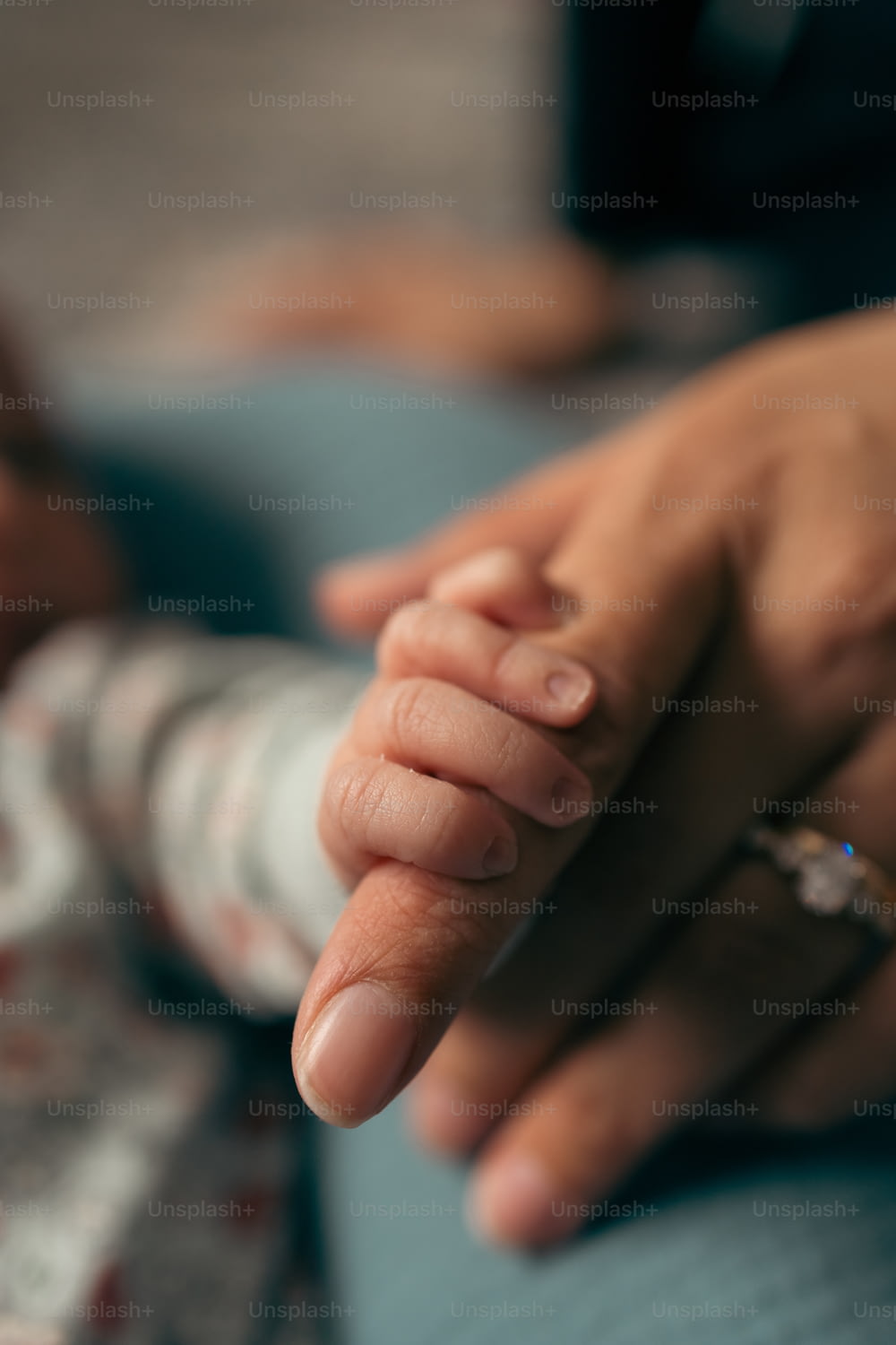 um close up de uma pessoa segurando a mão de um bebê