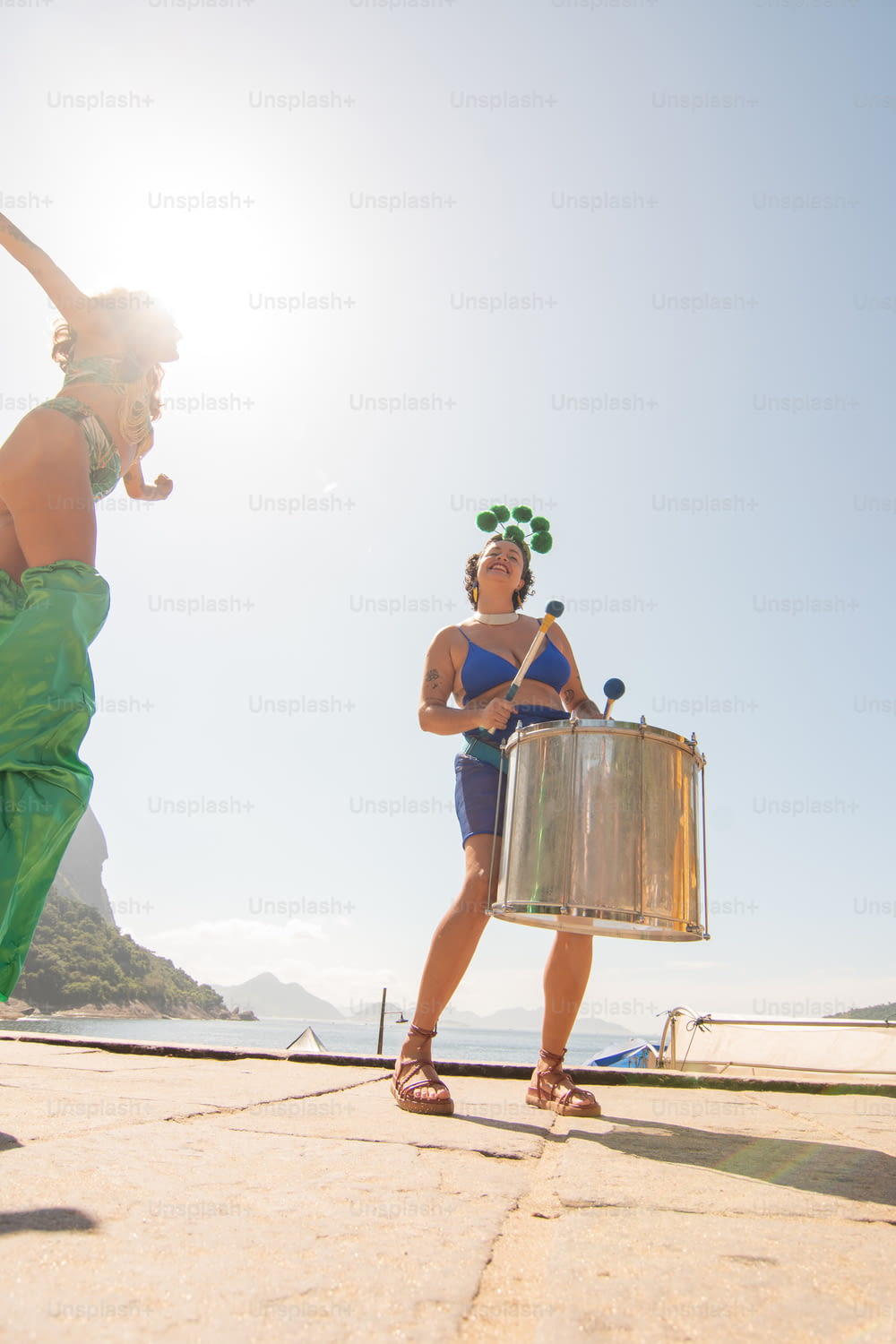 a woman in a bikini holding a large metal drum