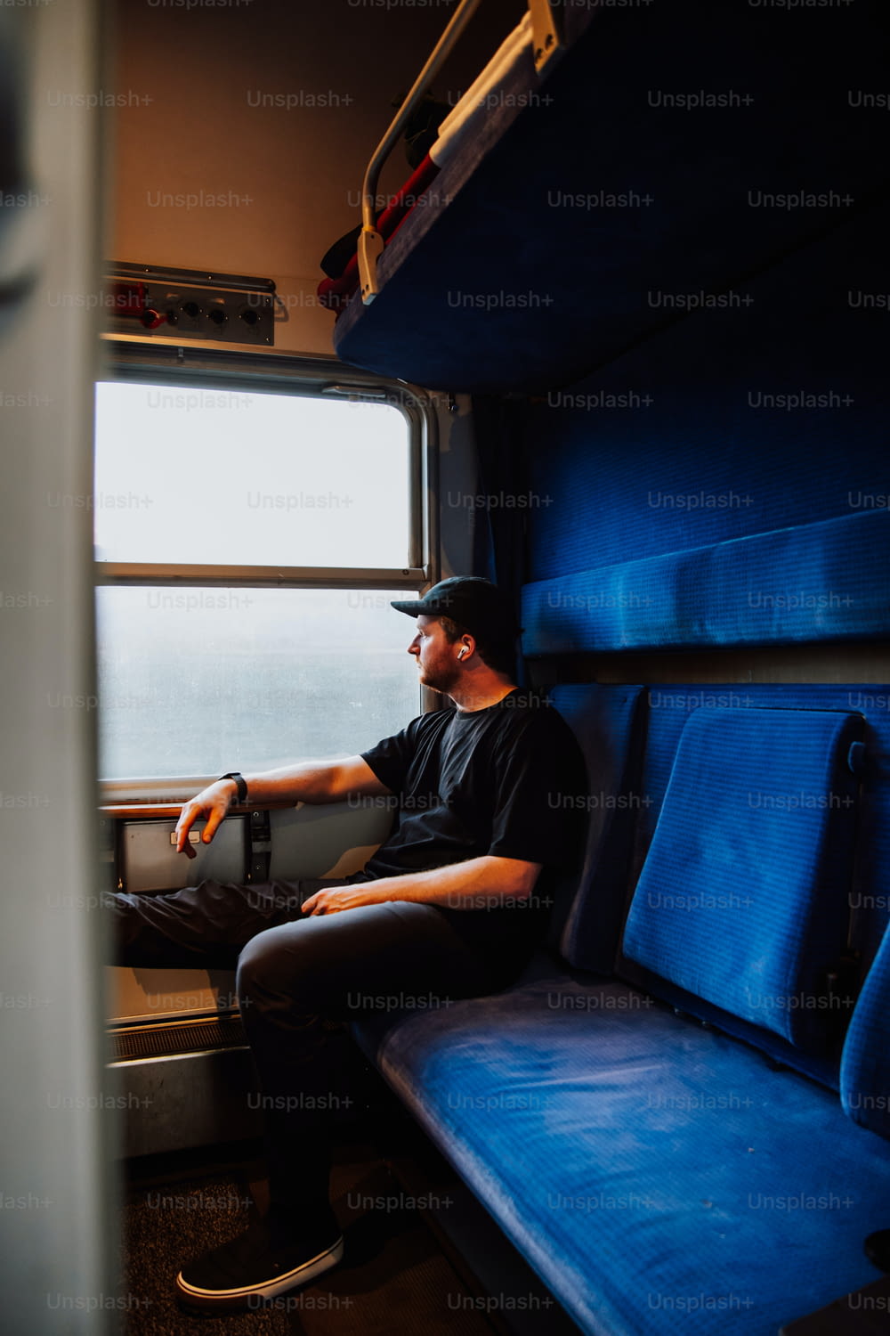 Un hombre sentado en un tren mirando por la ventana