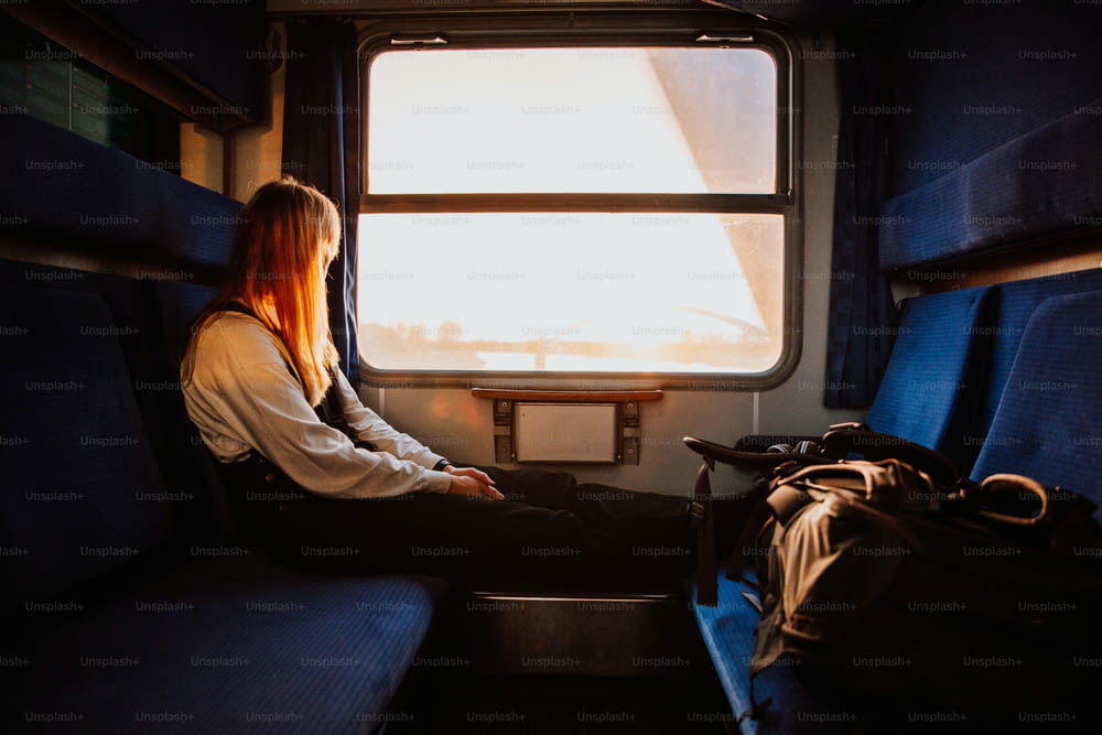 Una mujer sentada en un tren mirando por la ventana