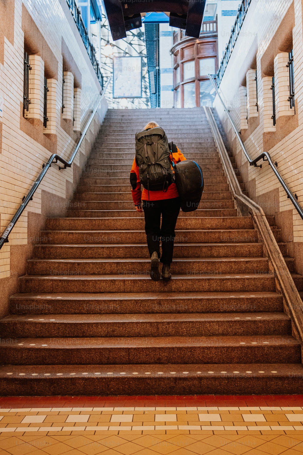 a person with a backpack walking up a flight of stairs