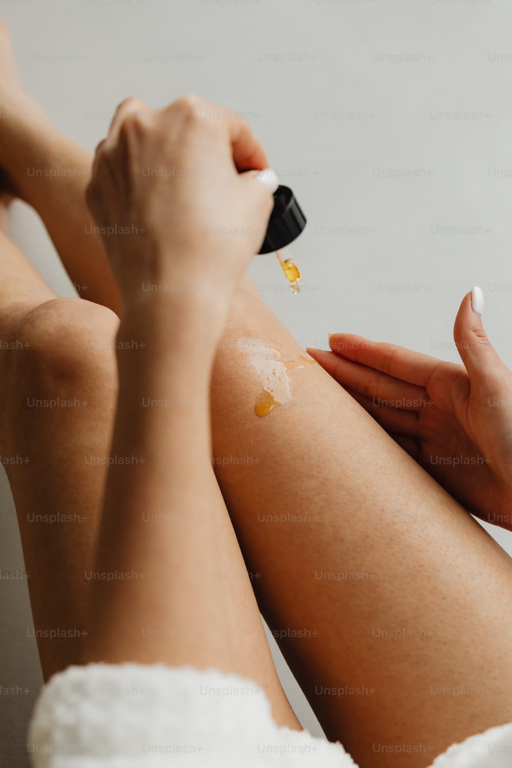 a woman applying a cream on her legs