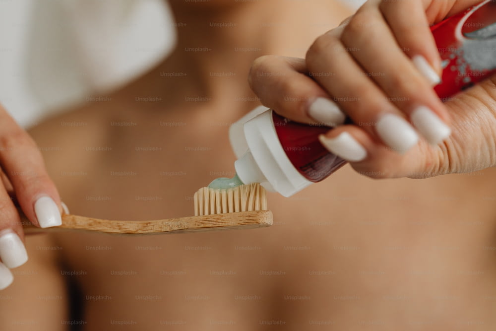 eine Frau, die sich mit einer Zahnbürste die Zähne putzt