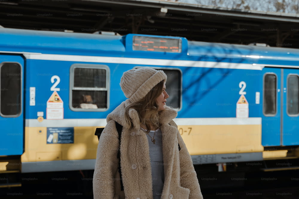 파란 기차 앞에 서 있는 여자