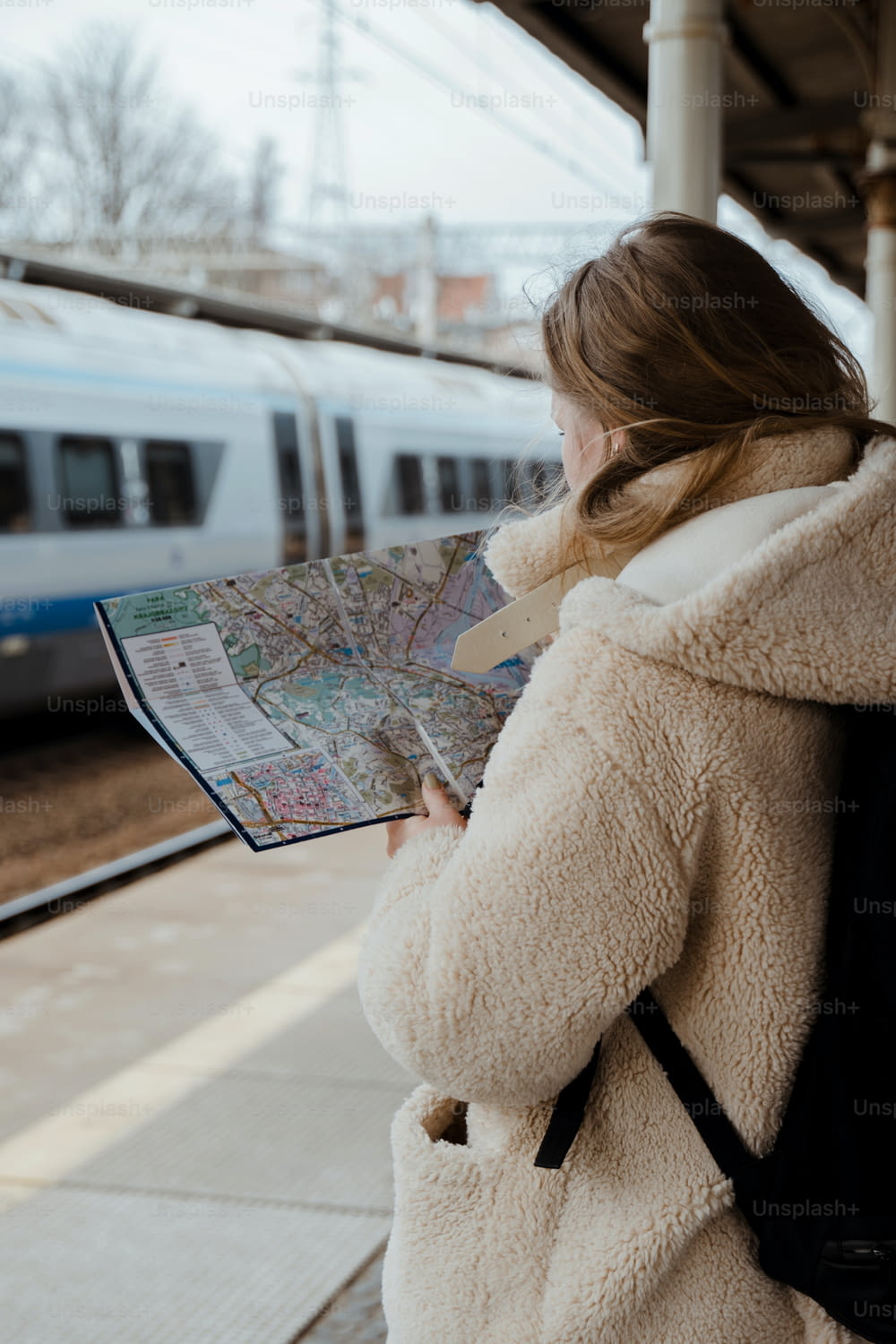 Una donna sta guardando una mappa mentre aspetta un treno