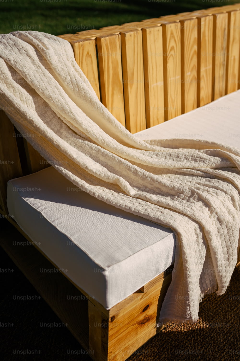une couverture blanche posée sur un banc en bois