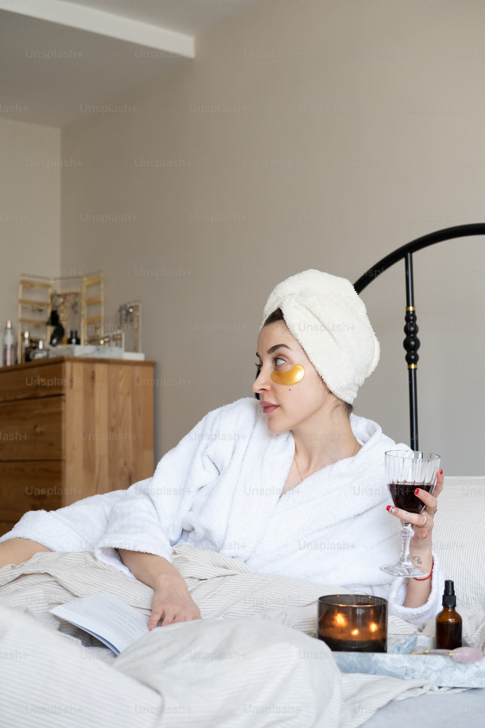 a woman in a bathrobe holding a glass of wine