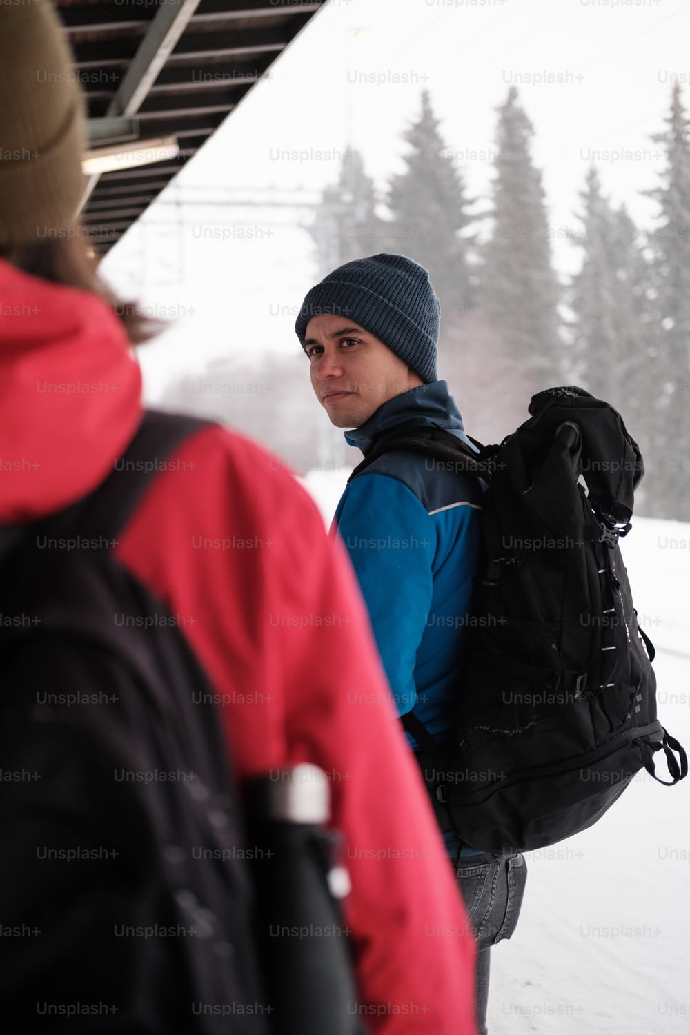 Un homme avec un sac à dos debout dans la neige