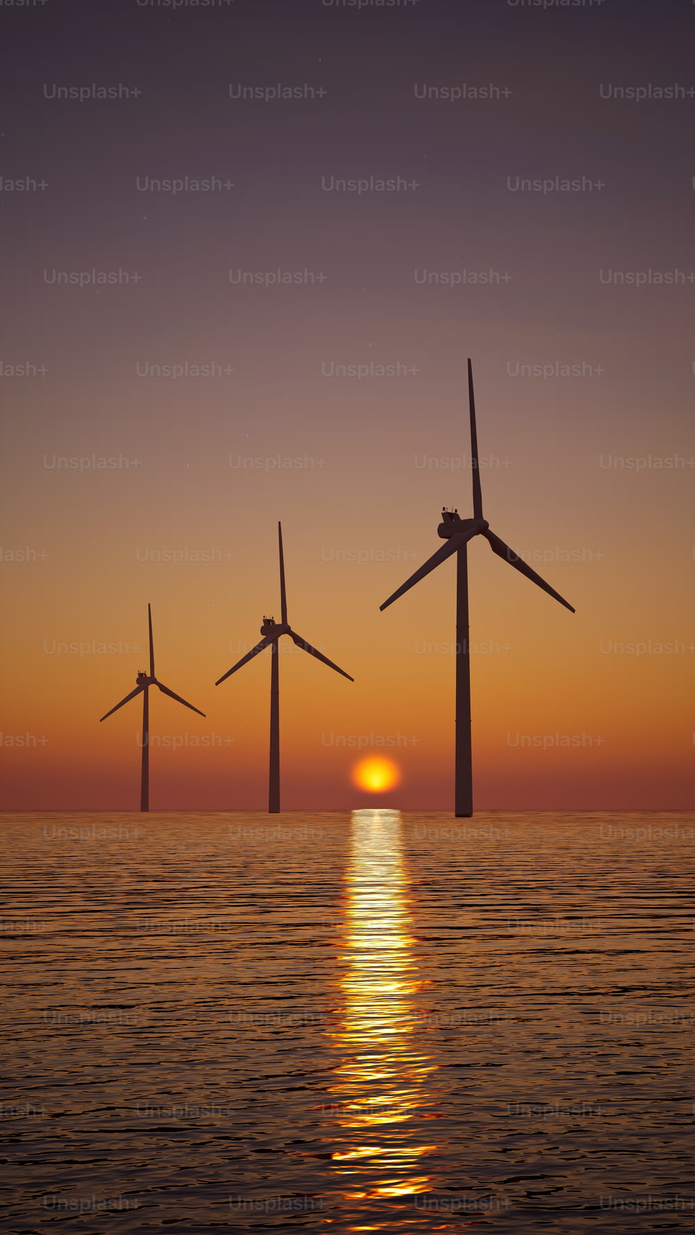 a group of windmills floating in the ocean at sunset