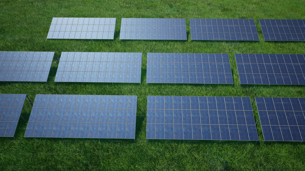 a group of solar panels laying on top of a lush green field