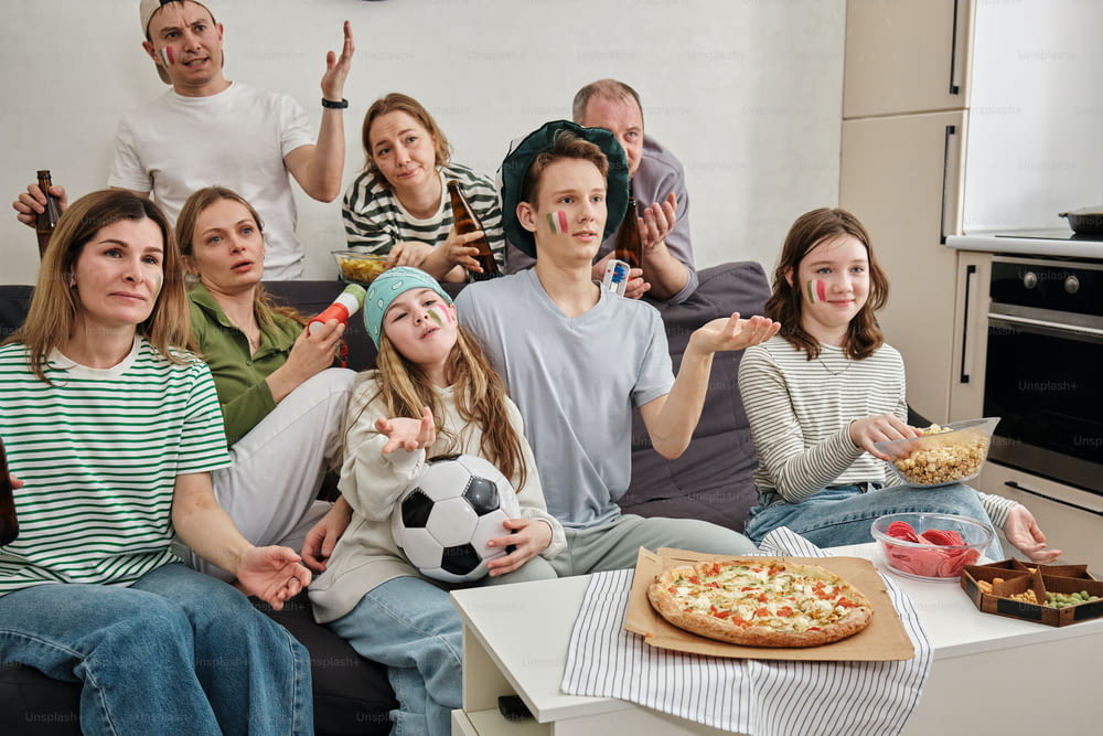 un groupe de personnes assises sur un canapé en train de manger une pizza
