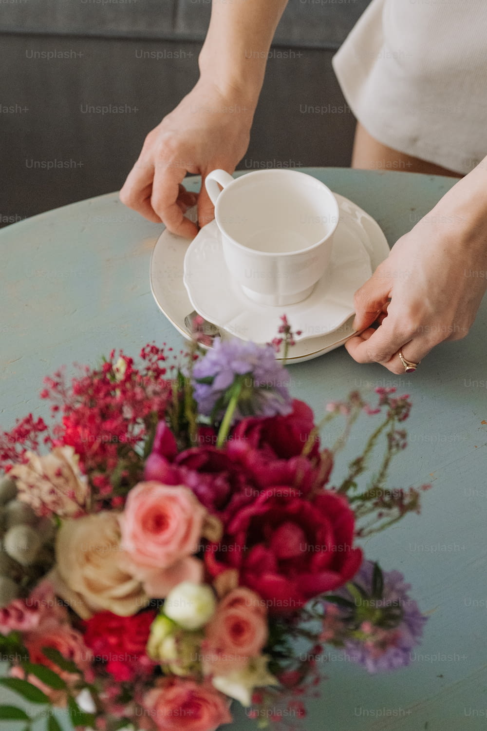 女性がテーブルに花を並べている