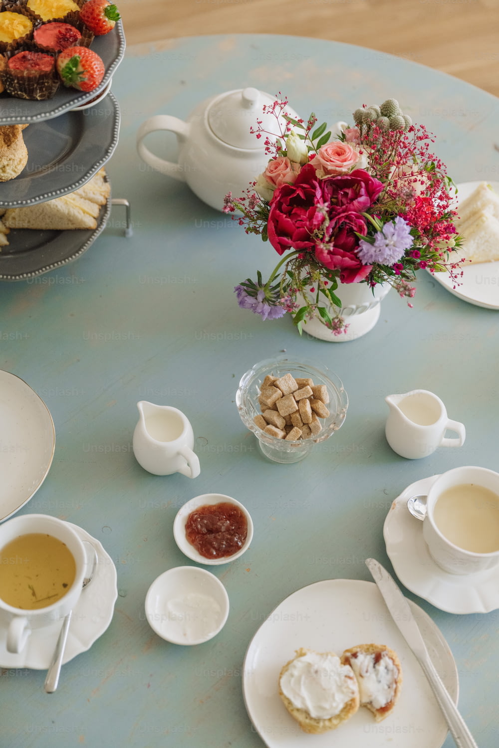 Ein Tisch mit Tellern mit Essen und Tassen Tee