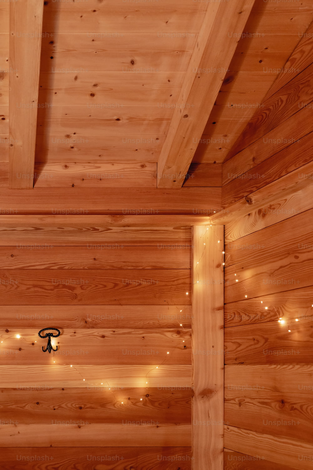 a bedroom with wooden walls and lights on the ceiling