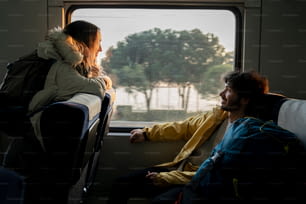 Un uomo e una donna seduti su un autobus che guardano fuori dal finestrino