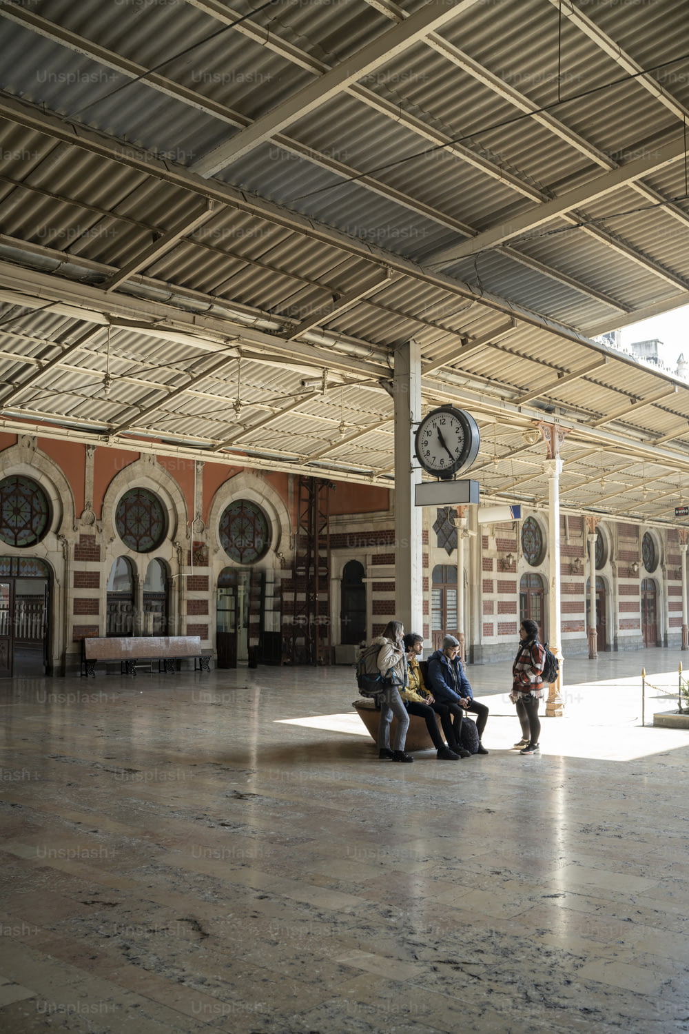 a group of people sitting on a bench in a train station