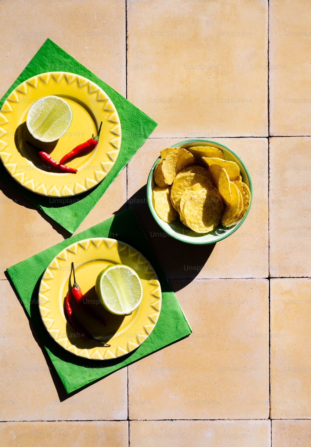 two bowls of chips and limes on a table