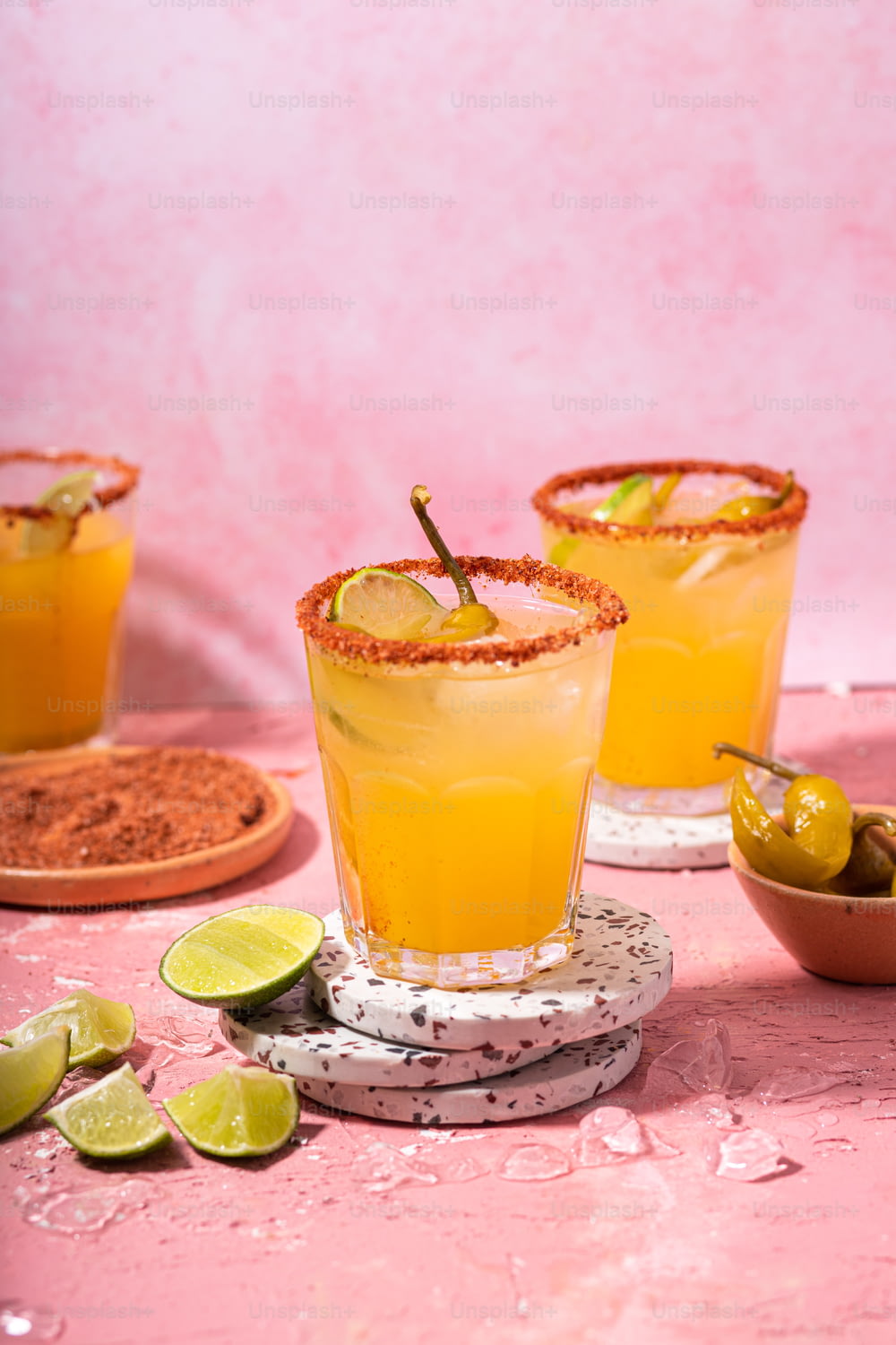 two glasses filled with orange juice and limes