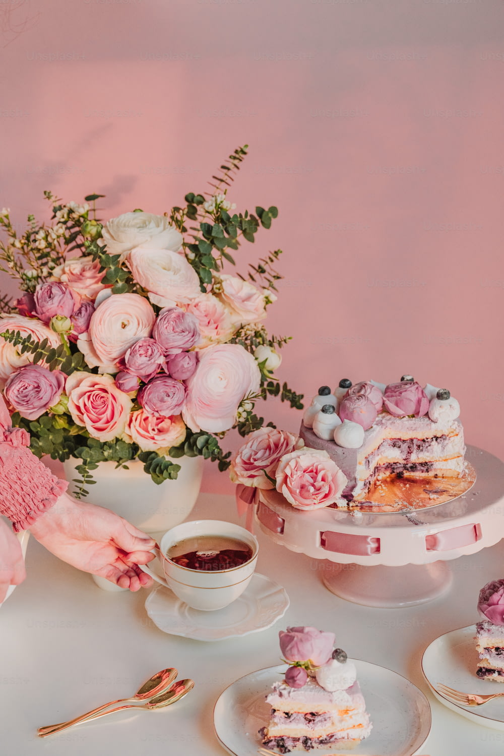 un tavolo bianco sormontato da torte e un vaso pieno di fiori