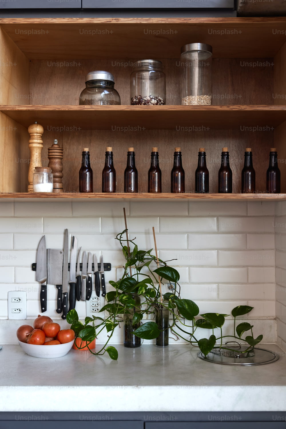 un bancone della cucina sormontato da un sacco di bottiglie e verdure