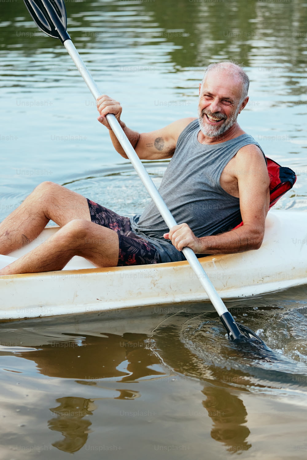 Ein Mann paddelt mit einem Kanu auf dem Wasser