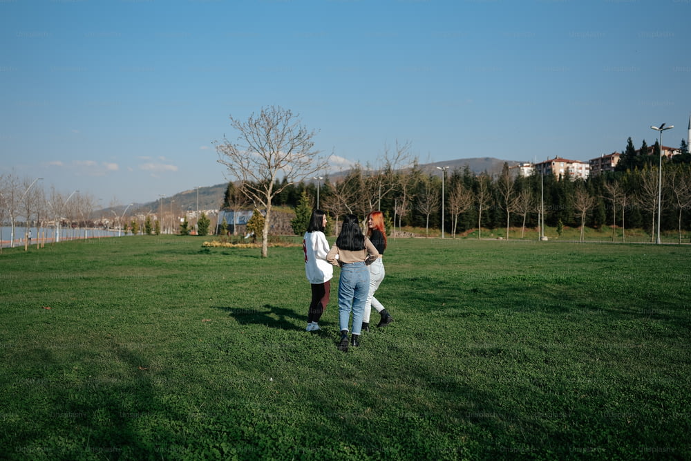 um grupo de pessoas em pé no topo de um campo verde exuberante