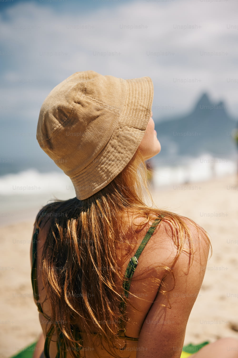 해변에 앉아 모자를 쓴 여자