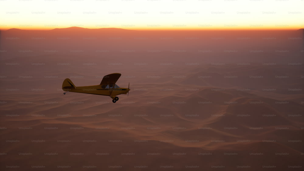 um pequeno avião voando sobre um deserto ao pôr do sol
