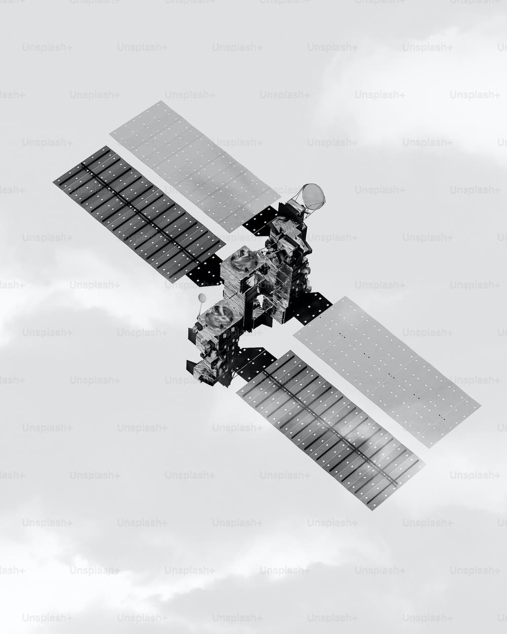 a black and white photo of a satellite in the sky