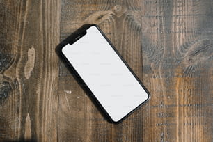 un teléfono celular sentado encima de una mesa de madera