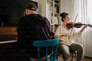 Ein Mann und eine Frau spielen Geige in einem Wohnzimmer