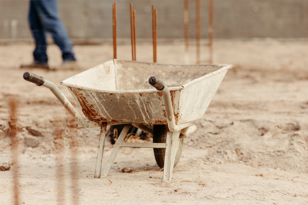 a wheelbarrow sitting in the middle of a dirt field