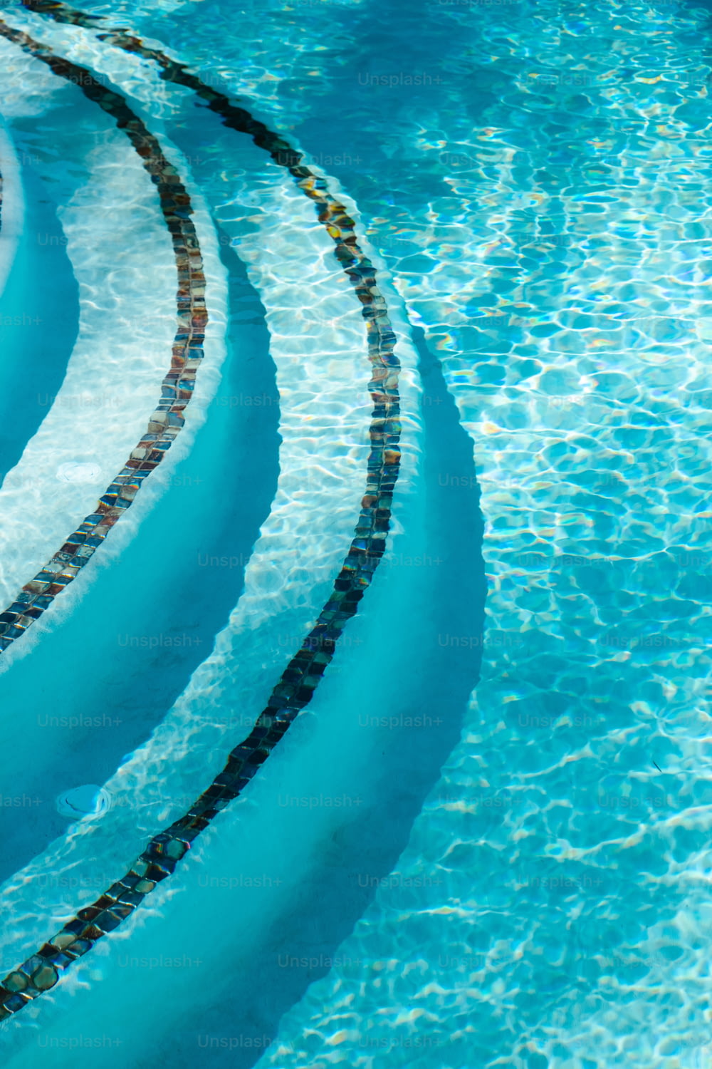 Une piscine avec de l’eau bleue et un design en spirale au milieu